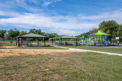 a park with a playground with a slide and swings at Historic Ludlow Apt B in Ludlow