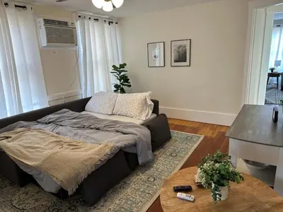 a living room with a bed and a table at Historic Ludlow Apt B in Ludlow