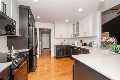 a kitchen with black and white appliances and wooden floors at Big Sky Retreat - Home for 10 in Fairfield