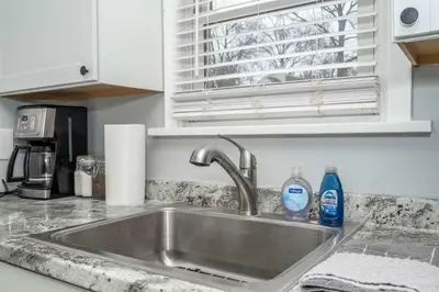 a kitchen sink with two bottles of detergent on it at Kenwood Keys Suites - for 12 in Cincinnati