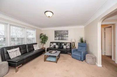 a living room with a black couch and a blue chair at Kenwood Keys Suites - for 12 in Cincinnati
