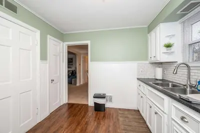 a kitchen with green walls and white cabinets and a sink at Kenwood Keys 2 - Stay for 6 in Cincinnati