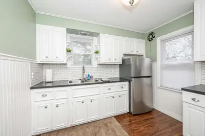 a kitchen with white cabinets and a stainless steel refrigerator at Kenwood Keys 2 - Stay for 6 in Cincinnati