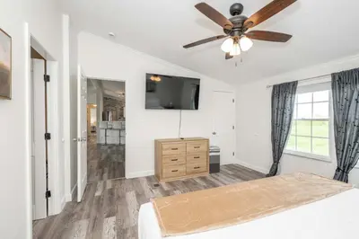 a bedroom with a ceiling fan and a television at Stillwater Hollow - For 10! in Williamstown