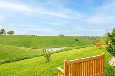 two benches sitting in a field with a river at Stillwater Hollow - For 10! in Williamstown