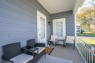 a porch of a house with two chairs and a table at Bridgetown Bungalow in Cincinnati