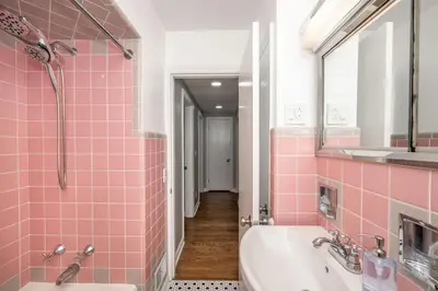 a pink tiled bathroom with a tub and a sink at Love 'n Life Haven in Cincinnati