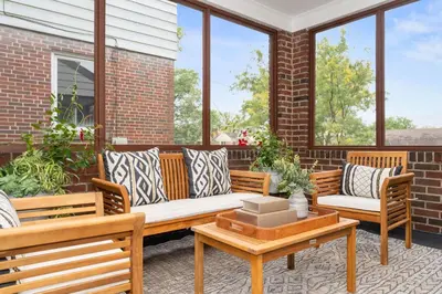 a porch with benches and tables and windows at The Cincinnati Charm in Cincinnati
