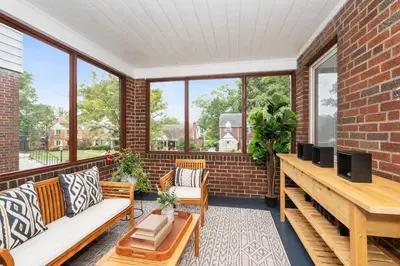 a screened in porch with furniture and windows at The Cincinnati Charm in Cincinnati
