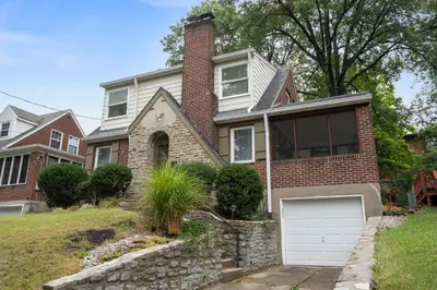 a brick house with a white garage at The Cincinnati Charm in Cincinnati