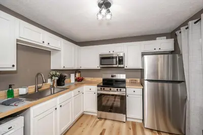 a kitchen with white cabinets and a stainless steel refrigerator at The Ark Encounter Getaway in Williamstown