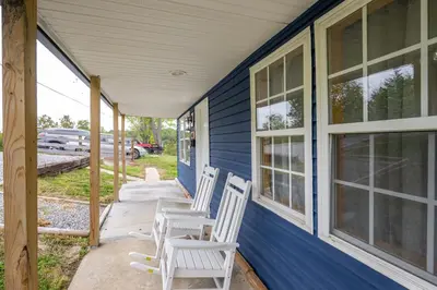 two white chairs sitting on the porch of a blue house at The Ark Encounter Getaway in Williamstown
