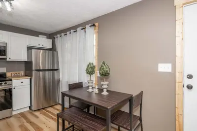 a kitchen with a table with two chairs and a refrigerator at The Ark Encounter Getaway in Williamstown