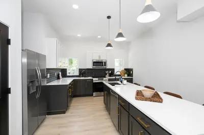 a kitchen with black cabinets and white counter tops at Heights on Wayne by Blackhouse in Cincinnati