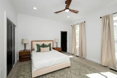 a white bedroom with a bed and a ceiling fan at Heights on Wayne by Blackhouse in Cincinnati