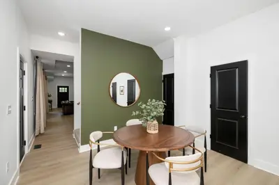 a dining room with a table and chairs and a mirror at Heights on Wayne by Blackhouse in Cincinnati