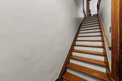 a staircase with wooden railings in a white room at Bella Notte Columbus in Columbus