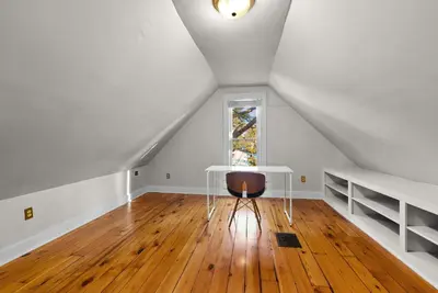 an attic room with a table and a window at Bella Notte Columbus in Columbus