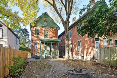 an old brick house with a green roof at Bella Notte Columbus in Columbus