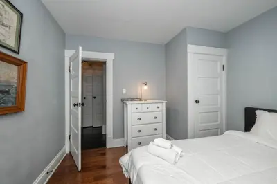 a bedroom with a bed and a dresser and a mirror at The Restful Roost w Hot Tub in Columbus