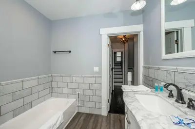 a white bathroom with a tub and a sink at The Restful Roost w Hot Tub in Columbus