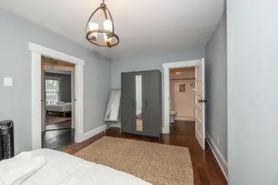 a bedroom with a bed and a hallway with a bathroom at The Restful Roost w Hot Tub in Columbus