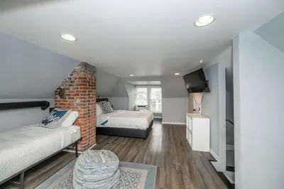 a room with two beds and a couch and a tv at The Restful Roost w Hot Tub in Columbus