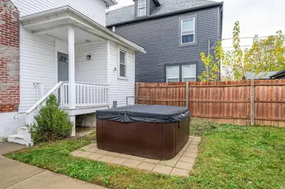 a house with a trash can in the yard at The Restful Roost w Hot Tub in Columbus