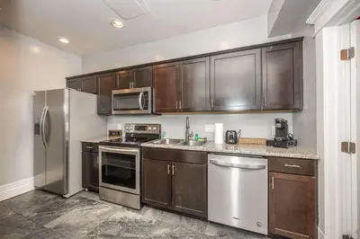 a kitchen with wooden cabinets and stainless steel appliances at The Restful Roost w Hot Tub in Columbus