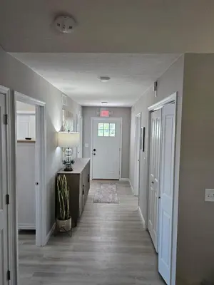 a hallway of a home with a door and a table and a lamp at New Construction 4 Bedroom Ranch in Trenton in Trenton