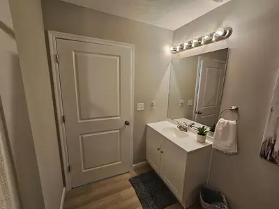 a bathroom with a white sink and a mirror at New Construction 4 Bedroom Ranch in Trenton in Trenton