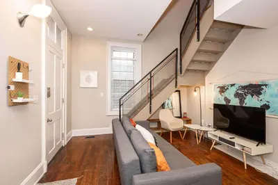 a living room with a gray couch and a tv at Loft Life Pendleton 2 - Chic Downtown Condo for 4 in Cincinnati