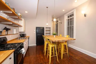 a kitchen with a wooden table and yellow stools at Loft Life Pendleton 2 - Chic Downtown Condo for 4 in Cincinnati