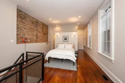 a bedroom with a bed and a brick wall at Loft Life Pendleton 2 - Chic Downtown Condo for 4 in Cincinnati