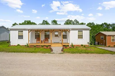 a small white house with a porch at 5 Neighboring Cabins at Eden Reserve - Front Five in Williamstown