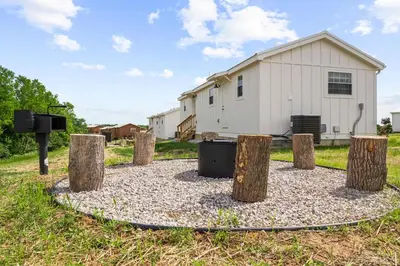 a circle of tree stumps with a building in the background at 5 Neighboring Cabins at Eden Reserve - Front Five in Williamstown