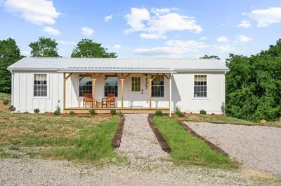 a small white house with a gravel driveway at The Lodges at Eden Reserve - Back Cabins - Near Ark in Williamstown