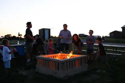 a group of people standing around a fire pit at The Lodges at Eden Reserve - Cabin Loop - Near Ark in Williamstown
