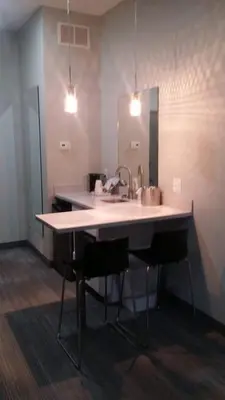 a kitchen counter with a sink and a mirror at Garland Hotel in New Concord