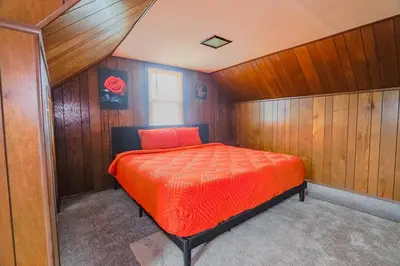 a bedroom with a bed in a room with wooden walls at 3 bedrooms at Cleveland in Euclid