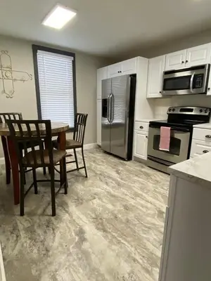 a kitchen with a table and chairs and appliances at London Maisonette - Red Door in London