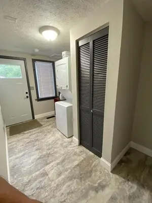 a room with a kitchen with a refrigerator and a door at London Maisonette - Red Door in London