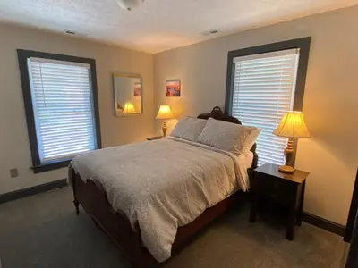 a bedroom with a bed with two lamps and two windows at London Maisonette - Red Door in London