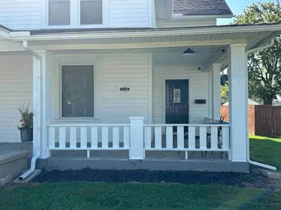 a white porch of a house with a white fence at London Maisonette - Black Door in London