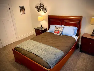 a bedroom with a bed with a wooden head board at London Maisonette - Black Door in London