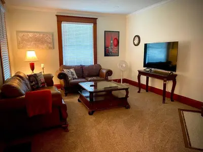 a living room with a couch and a tv and a table at London Maisonette - Black Door in London