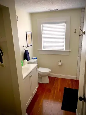 a bathroom with a toilet and a sink and a window at London Maisonette - Black Door in London