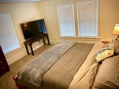 a bedroom with a bed and a flat screen tv at London Maisonette - Black Door in London