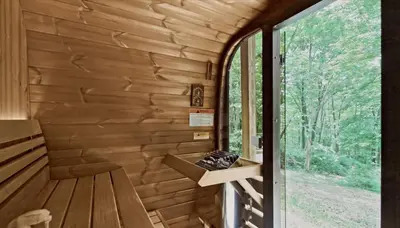 a wooden cabin with a bench and a window at Trails End Cabin- Sauna, Arcade, Hot Tub, Firepit in Logan