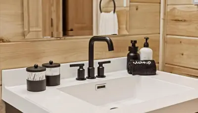 a kitchen counter with a sink with a faucet at Trails End Cabin- Sauna, Arcade, Hot Tub, Firepit in Logan